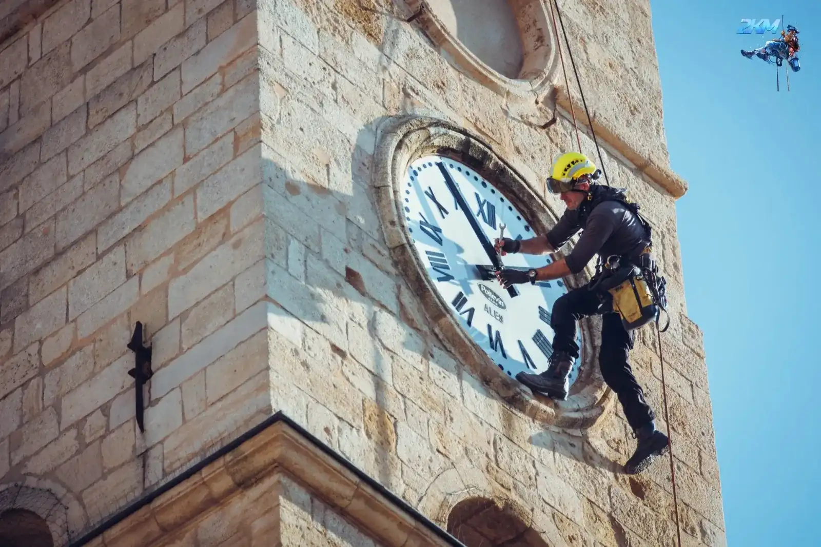 Cordiste 2KM intervenant sur le cadran d'horloge du clocher de l'abbatiale de Saint-Gilles-du-Gard