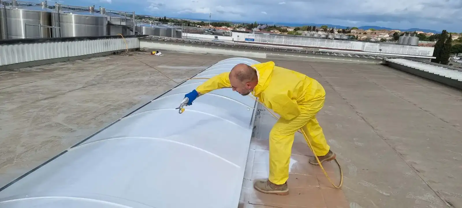 Application de peinture Cool Roof sur toiture industrielle a Beziers par 2KM