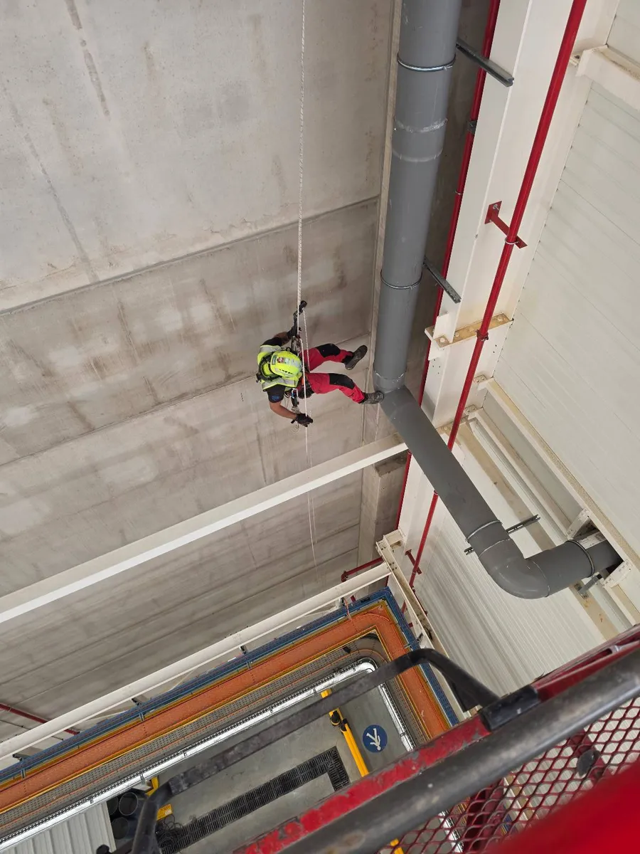 Cordiste 2KM en descente sur corde sous la charpente d'un hangar industriel près de Toulouse