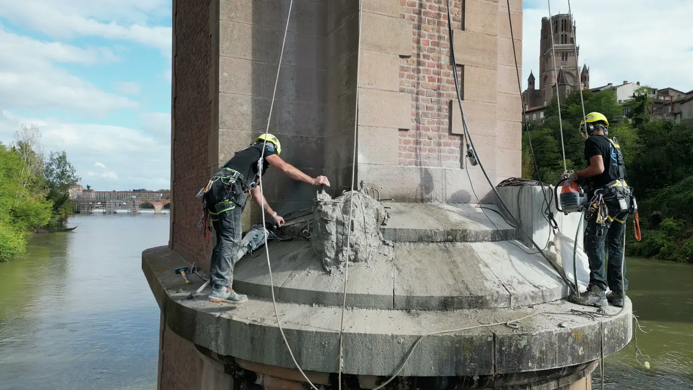 Cordistes 2KM sur l'avant-bec d'une pile du viaduc du Tarn, plot en béton en cours de démolition, armatures apparentes
