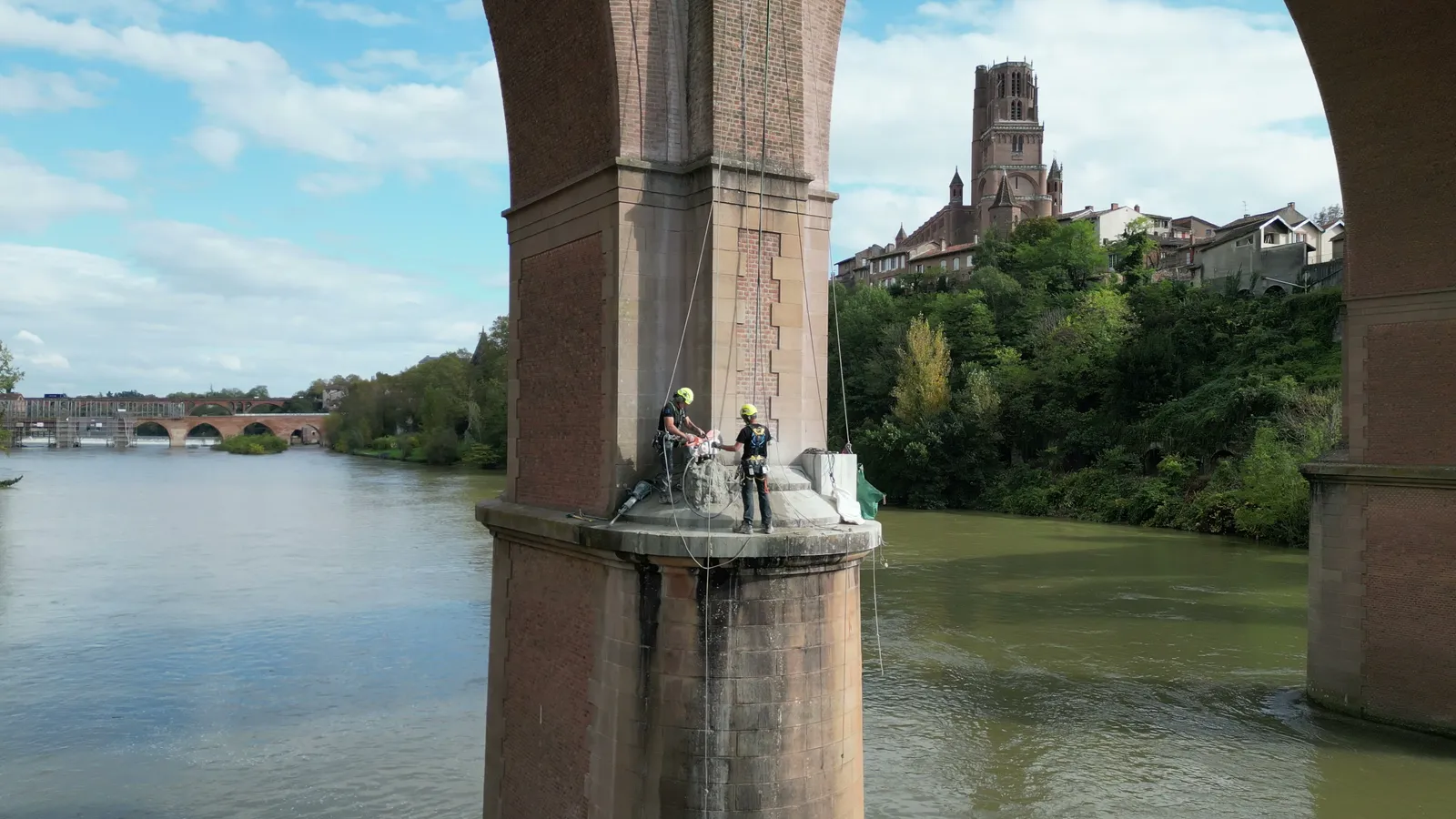 Deux cordistes 2KM sur l'avant-bec d'une pile du viaduc ferroviaire d'Albi, la cathédrale Sainte-Cécile en arrière-plan