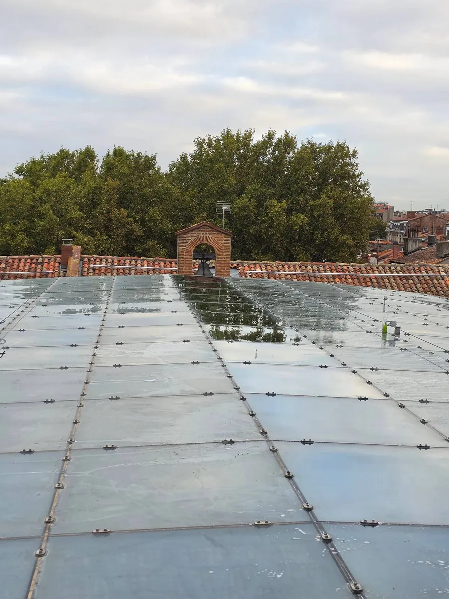 Avant et après sur la verrière du Tribunal judiciaire de Toulouse : une ligne de carreaux lavée à côté d'une ligne encore terne