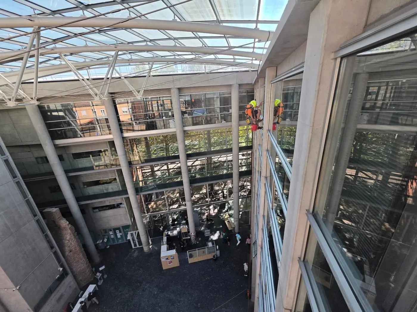 Atrium vitré du Tribunal judiciaire de Toulouse sur plusieurs étages, cordiste 2KM suspendu le long du vitrage sous la verrière