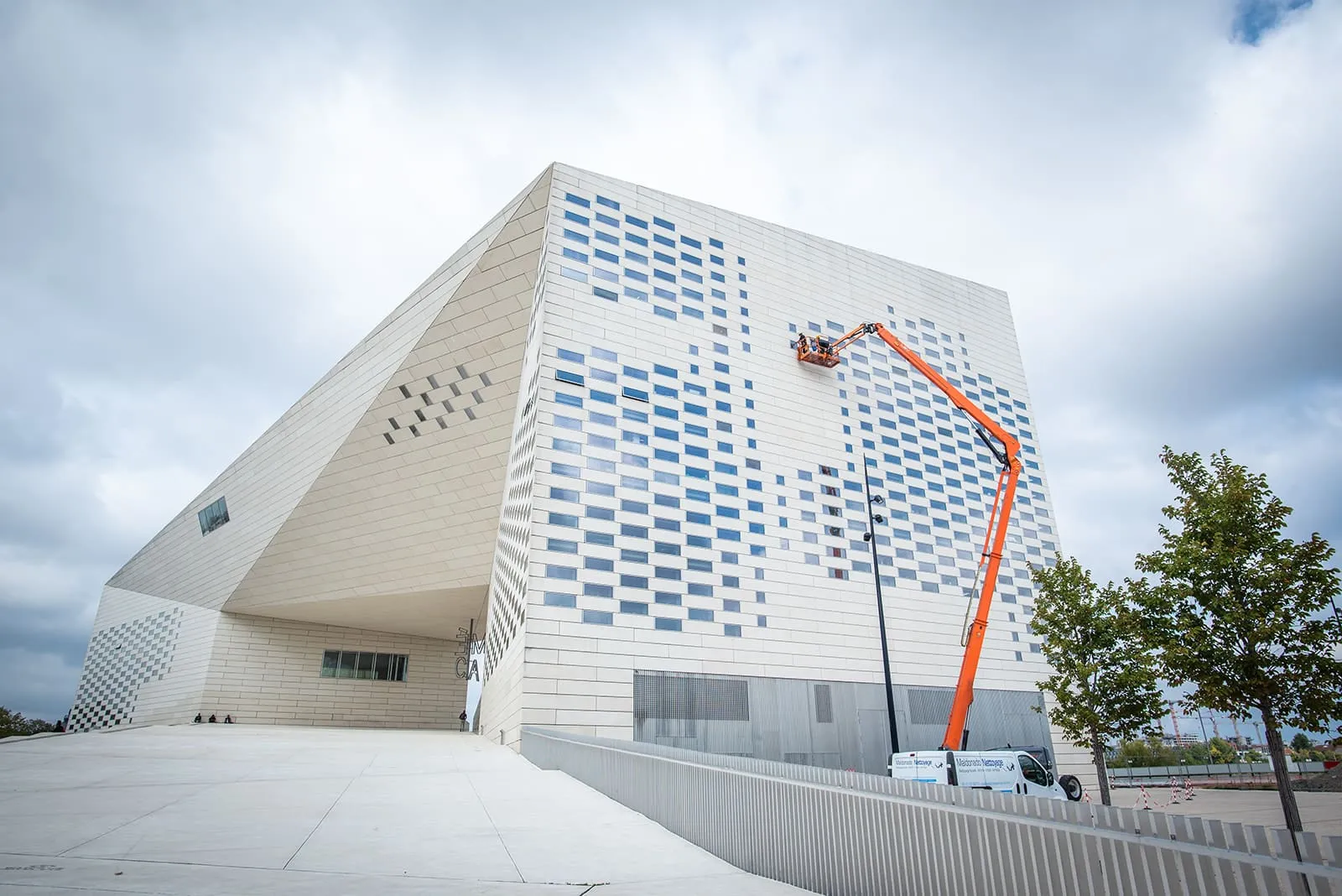 Nacelle 40 m en action sur la façade vitrée à damier de La Méca à Bordeaux