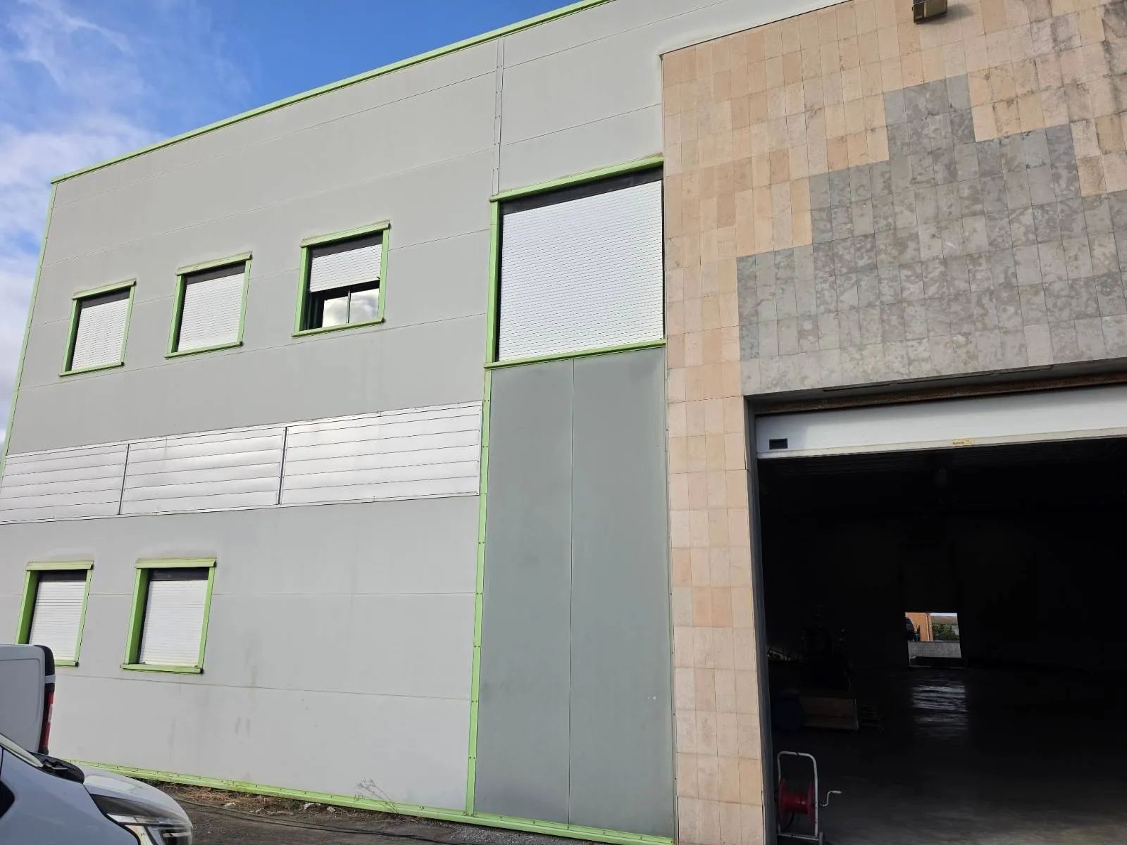 Façade du bâtiment d'activité avant travaux à Mauguio, bardage gris clair et liserés verts d'origine