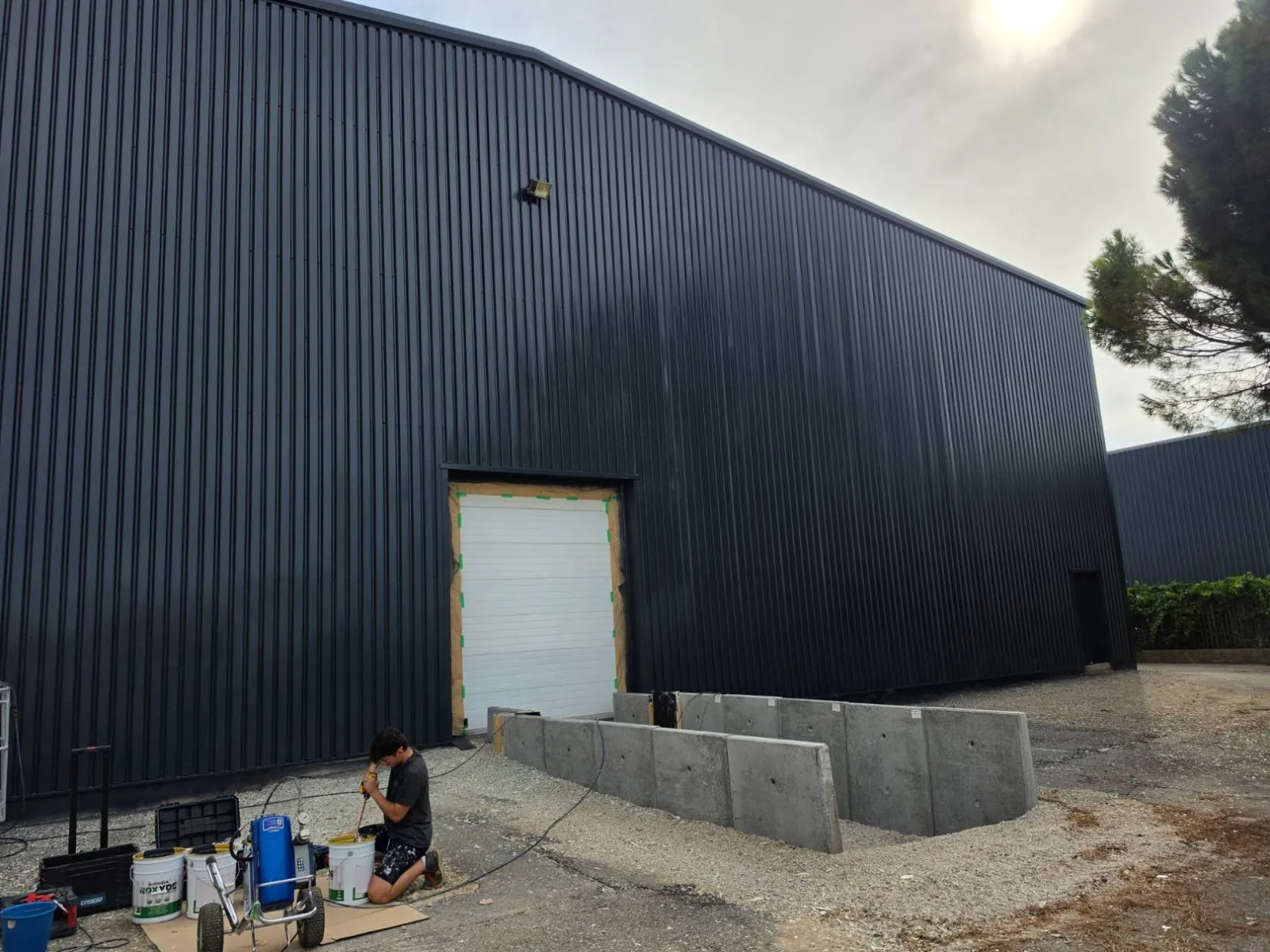Préparation des pots de Noxyde Plus et de la pompe airless au pied de la façade repeinte en anthracite