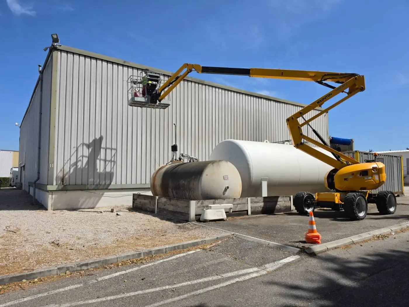 Cordiste 2KM en nacelle nettoyant le bardage Lomatrans au nettoyeur haute pression 500 bars