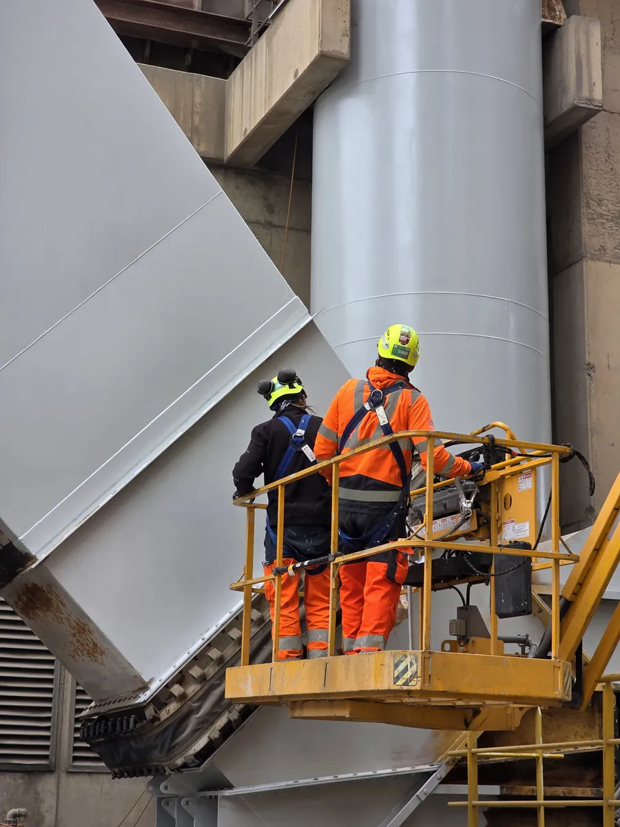 Technicien 2KM en nacelle appliquant la peinture anticorrosion sur la cheminee de la cimenterie Lafarge a Port-la-Nouvelle