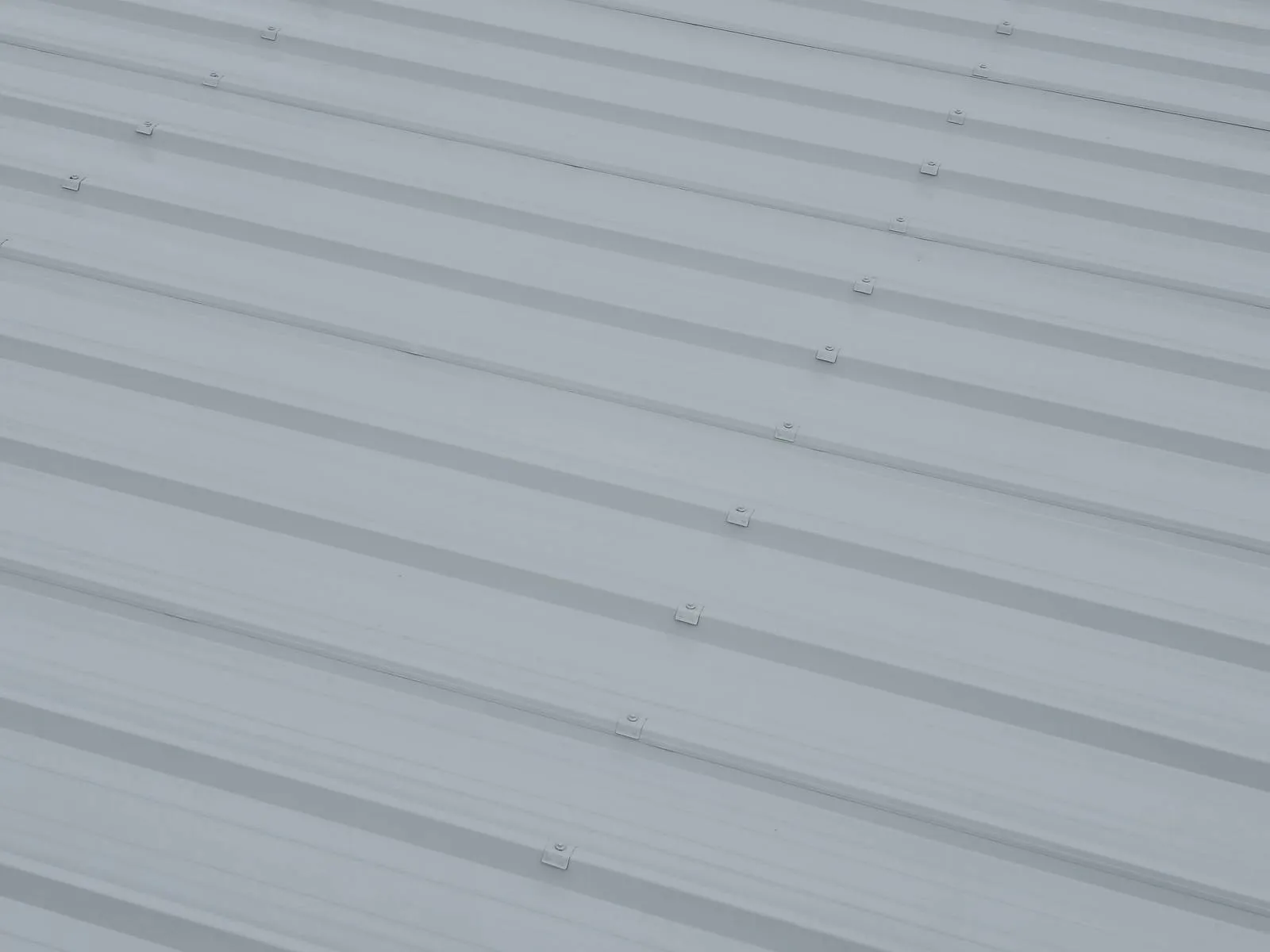 Detail des nervures et des fixations d une toiture bac acier apres mise en peinture au pistolet airless