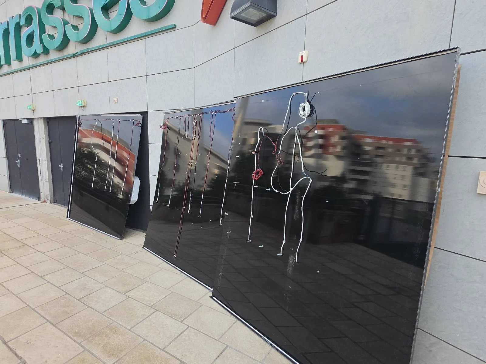 Câblage électrique des trois panneaux à lettres lumineuses avant leur mise en place en façade