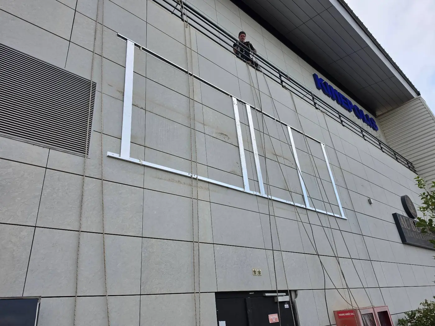 Support métallique fixé en façade pour recevoir l'enseigne lumineuse, côté gare, au Polygone de Béziers