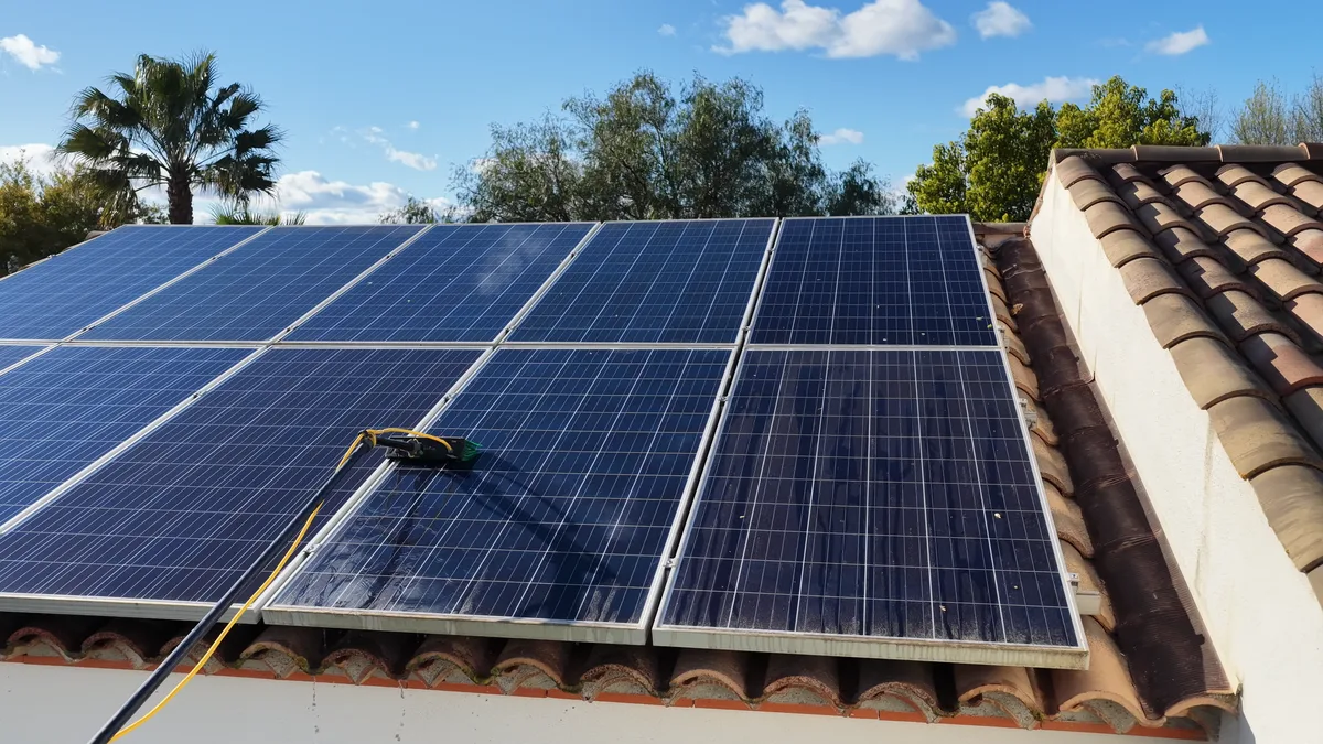 Brosse souple et eau déminéralisée sur un panneau photovoltaïque encrassé dans l’Hérault